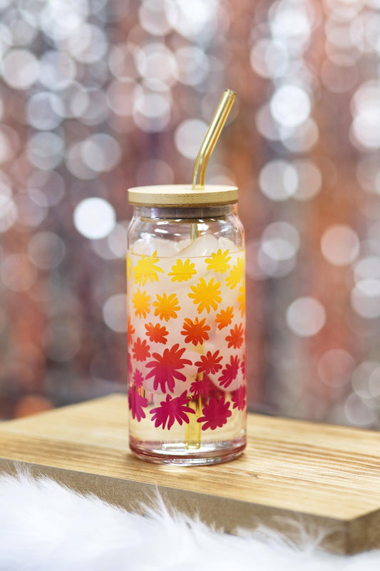 Clear glass tumbler with floral design on a wooden surface with a blurred bokeh background