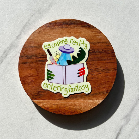 Sticker with 'escaping reality, entering fantasy' text on a wooden round object.
