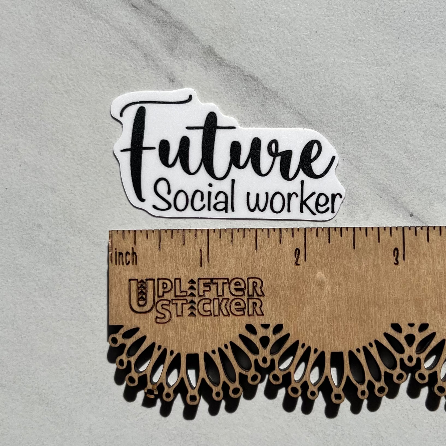 Sticker with 'Future Social Worker' text on a marble surface with a ruler for scale.
