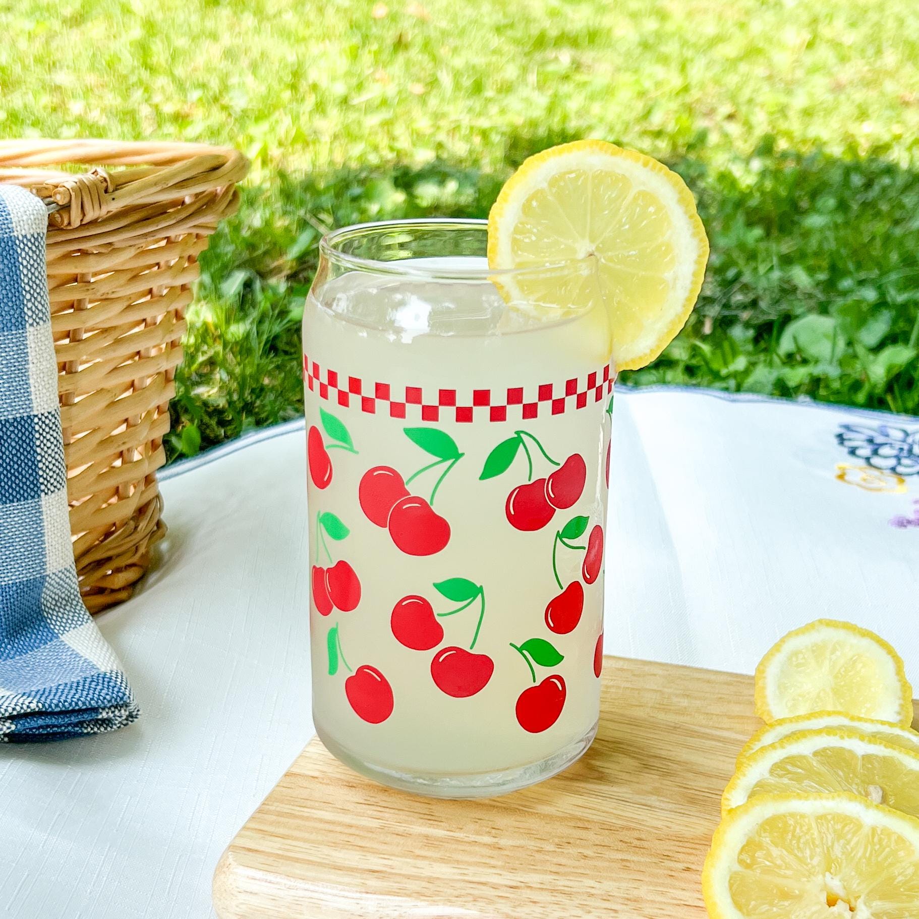 Glass with cherry design on a wooden cutting board outdoors