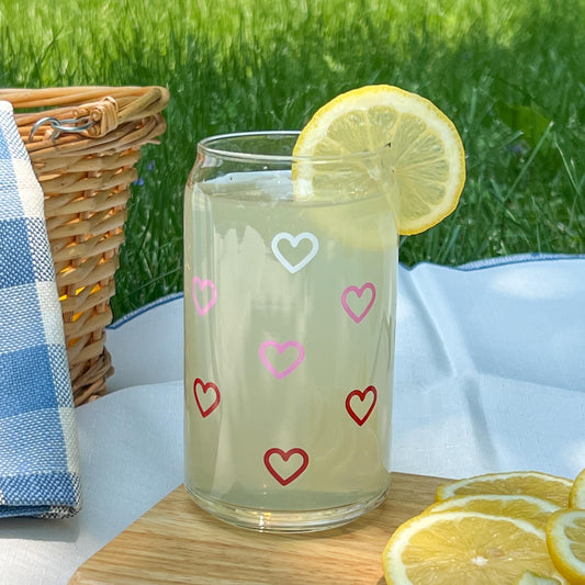 Glass of lemonade with white pink and red heart patterns on a picnic setting