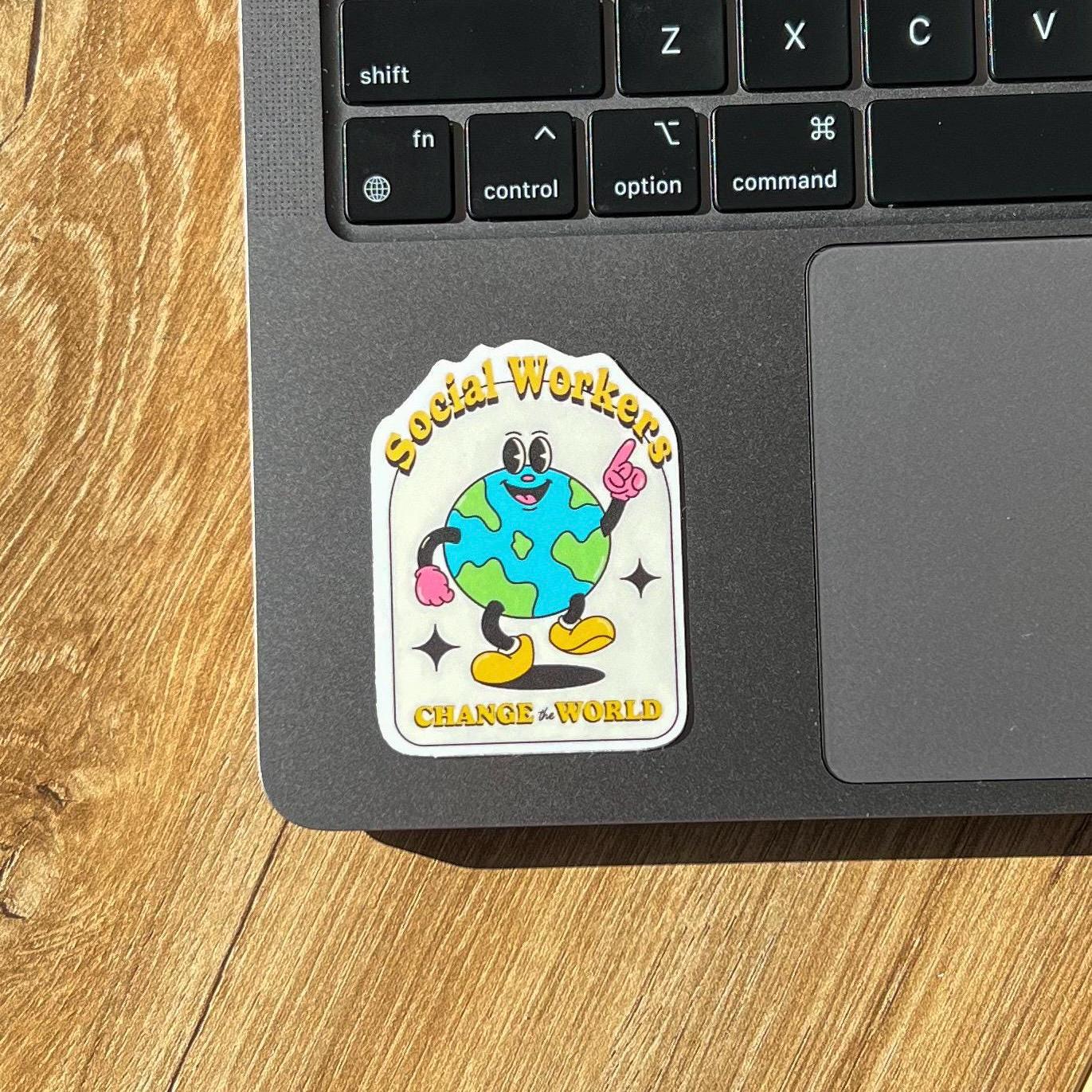 Laptop with a colorful sticker on the palm rest area, featuring a cartoon character and text.