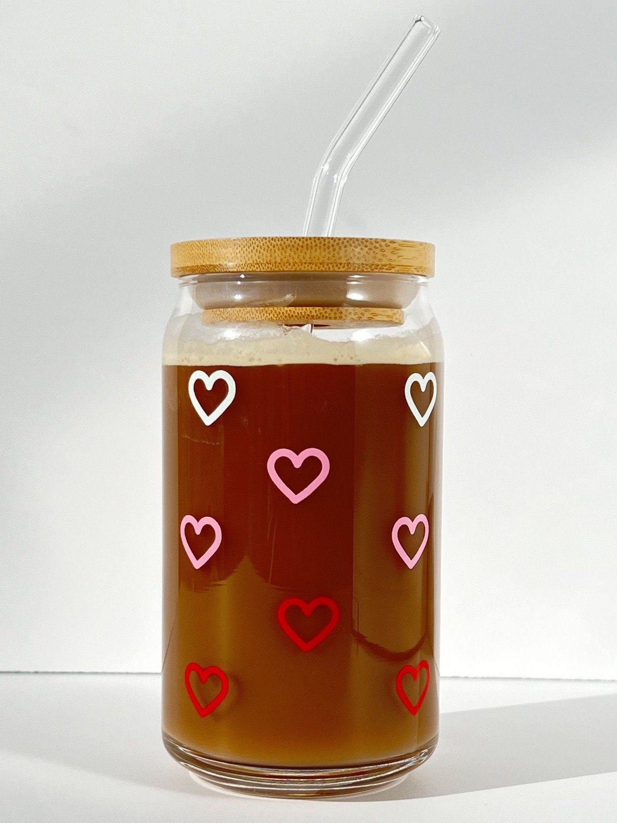 Jar of iced coffee with white, pink and red hearts on a white background