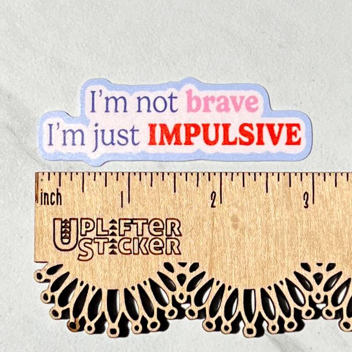 Sticker with text 'I'm not brave, I'm just IMPULSIVE' on a ruler for size reference.