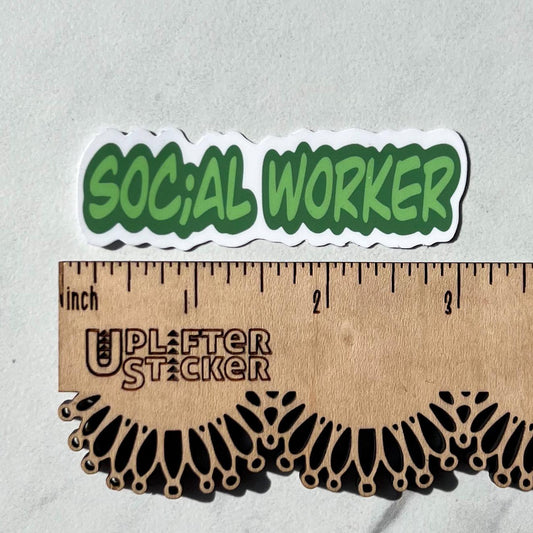 Green 'SOCIAL WORKER' sticker on a gray background with a ruler for scale.