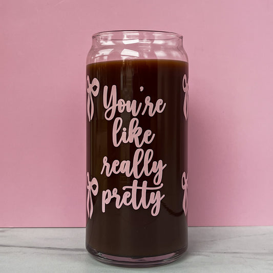Glass can with pink text that reads "you're like really pretty" with pink bows on a pink background